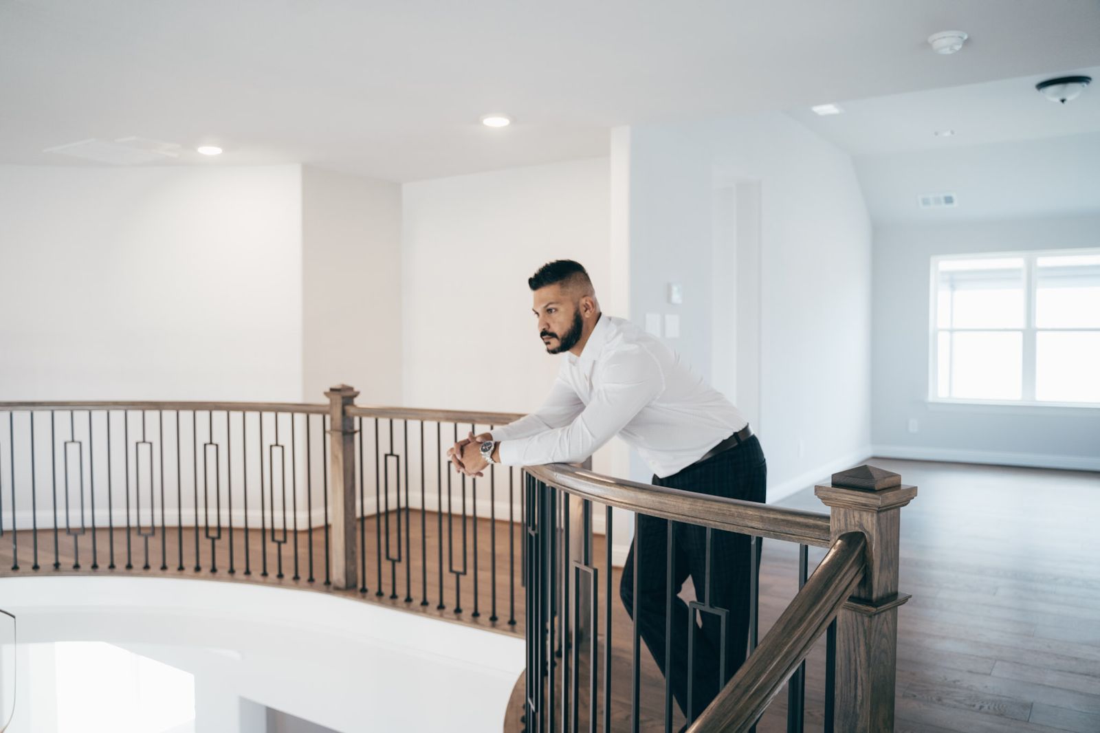 Thomson Thomas leaning on the upstairs railing of a DFW home