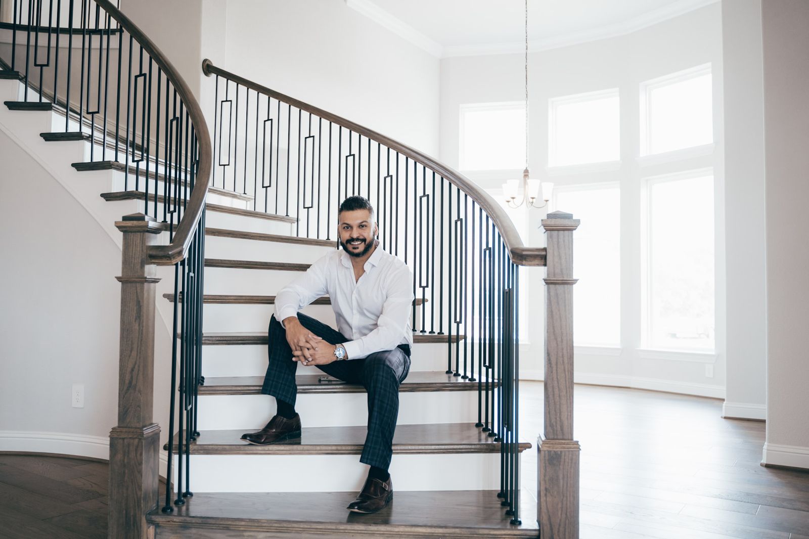 Thomson Thomas, Dallas-Fort Worth REALTOR, seated on the staircase of a new home